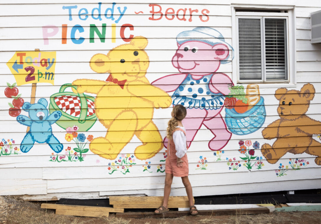 Girl in front of the teddy bear mural