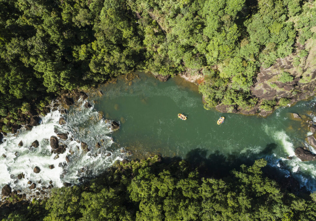 Aerial view of white water rafts in the rainforest surrounds of the Tully Gorge