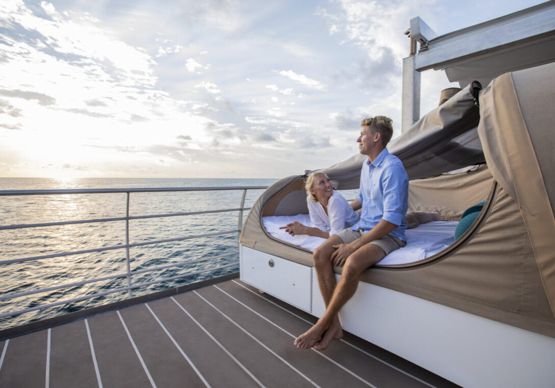 Couple sitting on their reef beds as the sun is setting, while on a Reefsleep