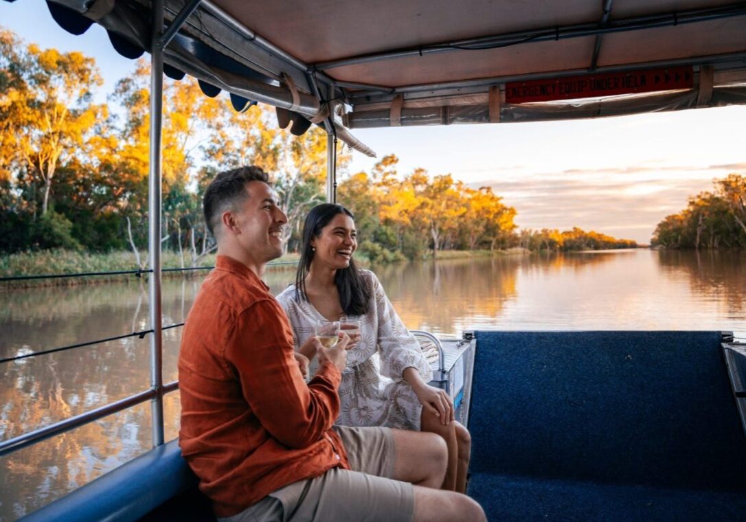 Couple enjoying a wine on the sunset cruise along the tranquil Balonne River